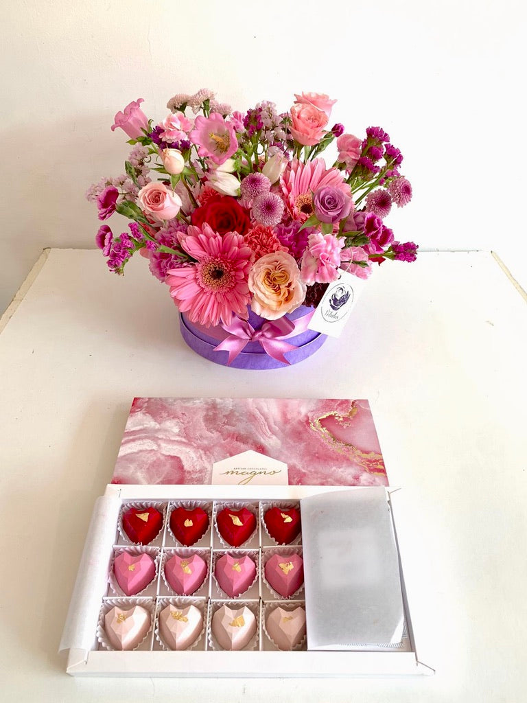 Jardincito morado, rosado, fucsia y lila con 12 corazones de chocolate