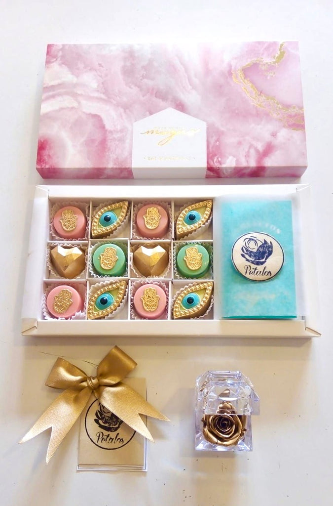 12 chocolates de amuletos rosados con rosa preservada dorada